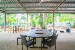 a wooden table and chairs in a patio at Zenhouse Worker Accom-Trailer - Storage - Pets in Nightcliff