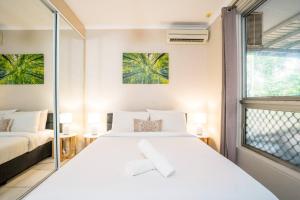 a bedroom with a large white bed and a window at Zenhouse Worker Accom-Trailer - Storage - Pets in Nightcliff