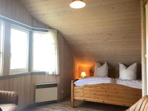 1 dormitorio con 1 cama en una pared de madera en Wildgans 129, en Mirow