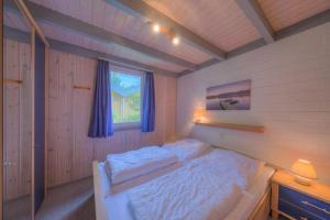 um quarto com uma cama branca num quarto com uma janela em Wildgans 130 em Mirow