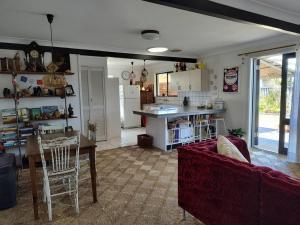 sala de estar con sofá rojo y cocina en McMansion: Sleeps 6, Walk to Beach, Pet Friendly en Golden Beach