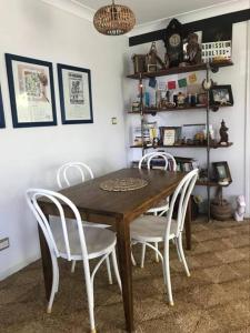 une salle à manger avec une table en bois et des chaises blanches dans l'établissement McMansion: Sleeps 6, Walk to Beach, Pet Friendly, à Golden Beach