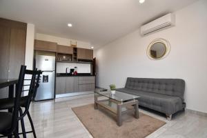 ein Wohnzimmer mit Couch und Tisch und eine Küche in der Unterkunft Loft de lujo con 9 albercas y vistas al campo de golf in Mazatlán