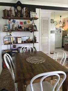 uma sala de jantar com uma mesa de madeira e cadeiras brancas em McMansion: Sleeps 6, Walk to Beach, Pet Friendly em Golden Beach