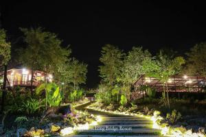 un giardino notturno con luci sulle scale di Happiness Long Bridge Resort 