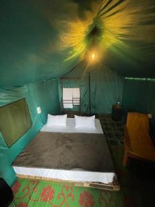 um quarto com uma cama numa tenda verde em Peacock Hill Glamp em Gampola