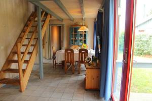 a dining room with a table and a staircase at Wildgans 269 in Mirow