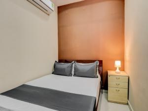 um pequeno quarto com uma cama e uma mesa de cabeceira em OYO HOTEL ORR RESIDENCY em Hyderabad