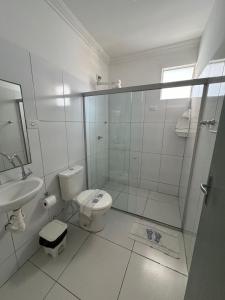 uma casa de banho com um chuveiro, um WC e um lavatório. em Pousada Maceió é Massa Praia de Pajuçara em Maceió