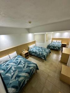 a hotel room with two beds and two chairs at Hotel Nueva Zelanda in León