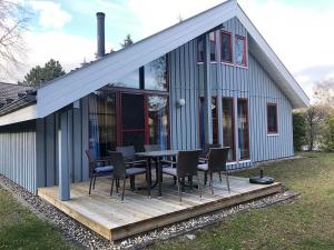 a house with a table and chairs on a deck at Wildgans 41 in Mirow