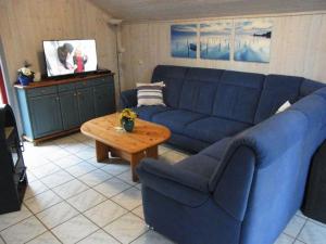 a living room with a blue couch and a table at Wildgans 42 in Mirow