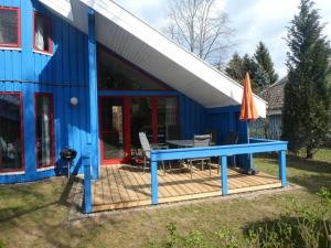 a blue house with a picnic table and an umbrella at Wildgans 42 in Mirow