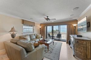 uma sala de estar com um sofá e uma televisão em Ola Grande 218 em Cocoa Beach