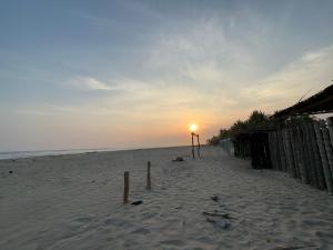 a beach with the sun setting on the horizon at ZONA DE CAMPING ANGEL DE EL MAR in Playa Azul