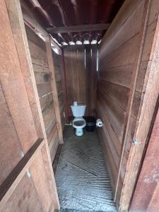 a bathroom with a toilet in a wooden stall at ZONA DE CAMPING ANGEL DE EL MAR in Playa Azul