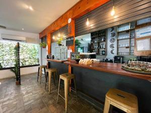 un restaurante con barra y taburetes en una habitación en Surf Ranch Tamarindo, en Tamarindo