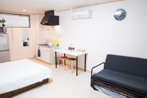 ein Schlafzimmer mit Bett und eine kleine Küche in der Unterkunft 難波南34 in Osaka
