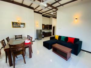 a living room with a couch and a table at Tango Sunrise Villa in Tangalle