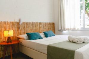 two beds in a room with a lamp on a table at Palace Beach Hostel in Rio de Janeiro