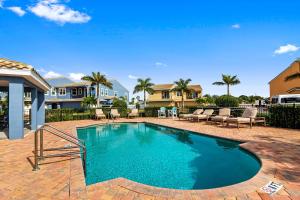 una piscina en un patio con sillas y casas en 116 Mediterranean Way, en Indian Harbour Beach