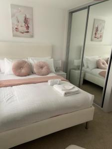a bedroom with a bed with pink pillows and a mirror at Brand New 3 Bedrooms Detached House in Westhoughton