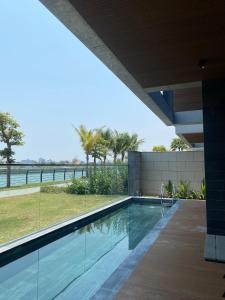 uma piscina de beiral infinito numa casa com vista para o oceano em LUXURY VILLA with 5 BEDROOMS RIVER VIEW em Da Nang