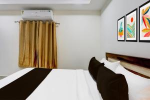 a bedroom with a white bed and a window at Super Collection O Madhapur near Cyber Tower in Hyderabad
