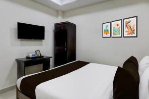 a bedroom with a bed with a television and a table at Collection O Madhapur near Cyber Tower in Hyderabad