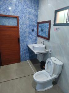 a bathroom with a toilet and a sink at Mango Guesthouse in Pangandaran