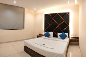 um quarto com uma cama grande e um ecrã de projecção em Townhouse OAK Hotel Hardik Palace Sector 116 em Noida