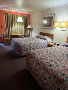 um quarto de hotel com duas camas e uma mesa em Budget Inn - Scottsboro em Scottsboro