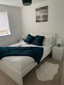a bedroom with a large white bed with green pillows at Brand New 3 Bedrooms Detached House in Westhoughton