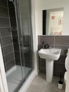 a bathroom with a shower and a sink and a toilet at Brand New 3 Bedrooms Detached House in Westhoughton