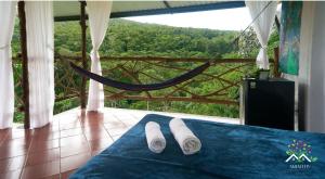 a pair of slippers on a bed in a room with a hammock at Hostal Ariantiy in Pepino