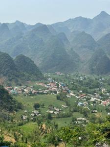 une petite ville dans une vallée entourée de montagnes dans l'établissement Viet Hung Hostel - Motorbikes Rental- BUS TICKET, à Làng Lap