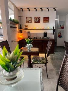 ein Wohnzimmer mit einem Tisch und Stühlen sowie eine Küche in der Unterkunft Pousada Cristais SUITE 15 in Teófilo Otoni