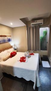 ein Schlafzimmer mit einem Bett mit roten Rosen darauf in der Unterkunft Pousada Cristais SUITE 15 in Teófilo Otoni