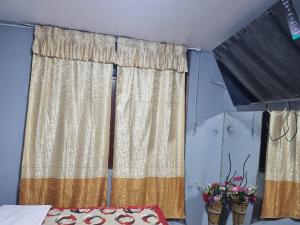 Una cortina en una habitación con dos jarrones de flores en Hostal Chavin, en Lima