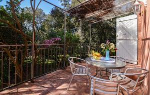 d'une terrasse avec une table, des chaises et une clôture. dans l'établissement Cozy Home In Piscia Rossa With Wifi, à Afa