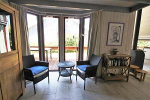a living room with chairs and a table and windows at Wildgans 267 in Mirow