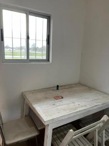 a table and a chair in a room with a window at Casa en El Pinar in Ciudad de la Costa