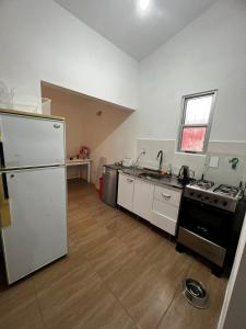 a kitchen with a white refrigerator and a sink at Casa en El Pinar in Ciudad de la Costa