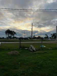 a field with two rocks and a road with a fence at Casa en El Pinar in Ciudad de la Costa