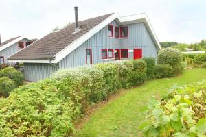 a blue house with red windows and a yard at Wildgans 273 in Mirow