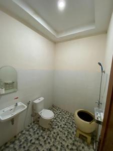 a bathroom with a toilet and a sink at Family Room with Rice Field View in Borobudur