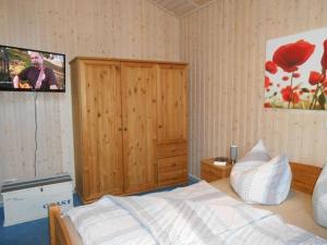 a bedroom with a bed and a tv on the wall at Haubentaucher 80 in Rechlin