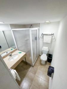 a bathroom with a shower and a toilet and a sink at Hotel Nueva Zelanda in León