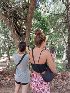two women are looking up at a tree at Ridge Boundary View in Dambulla