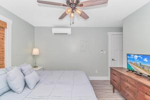 a white bedroom with a bed and a ceiling fan at Beachside Retreat - Garden City - Murrells Inlet in Myrtle Beach